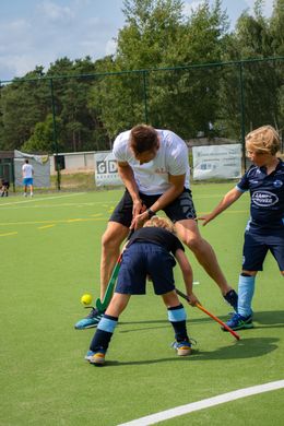 Hans van Alphen speelt hockey met kinderen